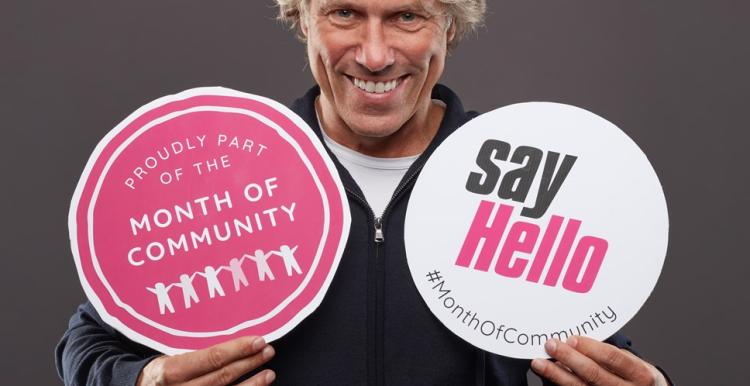 a man holds two signs that say "say hello"