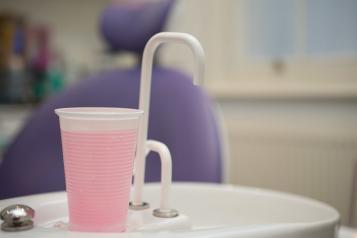 Mouthwash and tap in front of a dentist chair