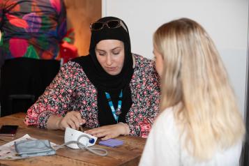 Two women talking over a blood pressure monitor