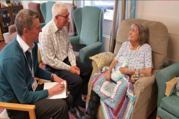 Two healthwatch Dudley volunteers talk to an older woman.