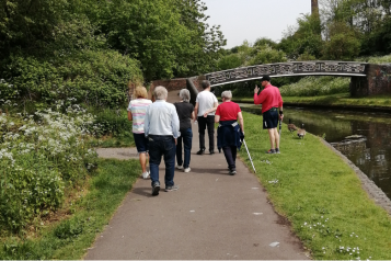 group of people walking alongside a canal