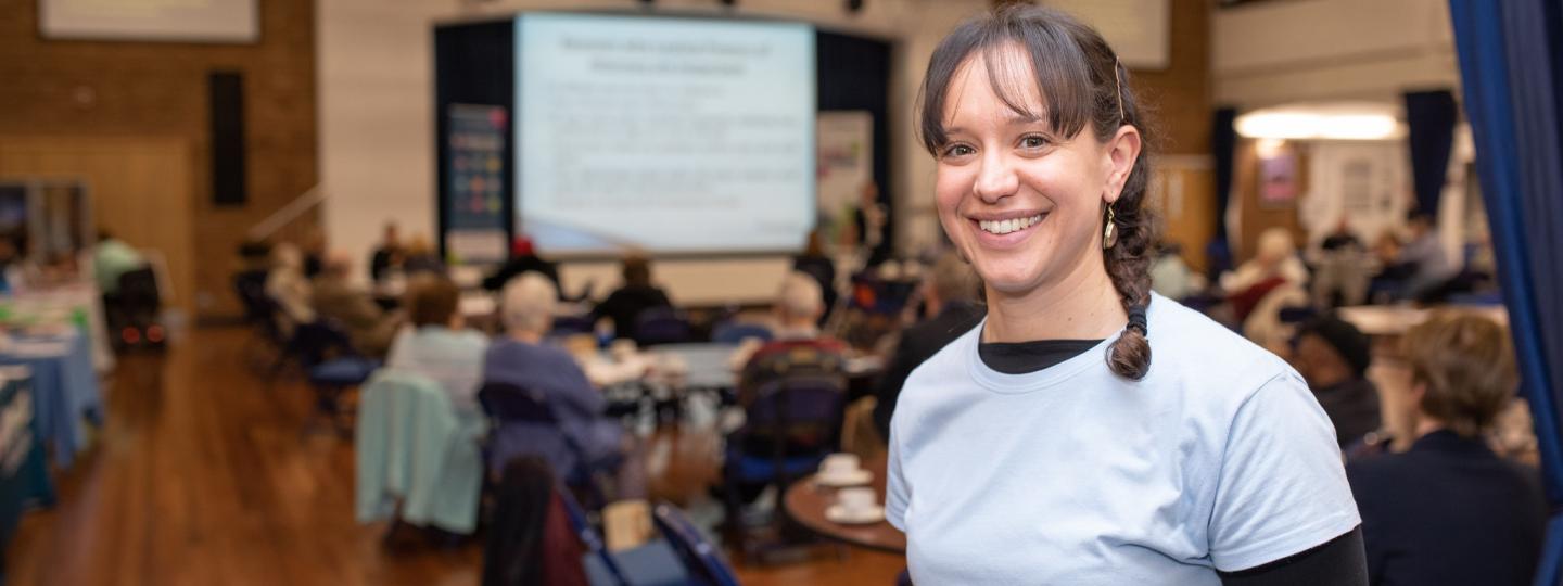 Woman smiling at the camera in a busy indoor event