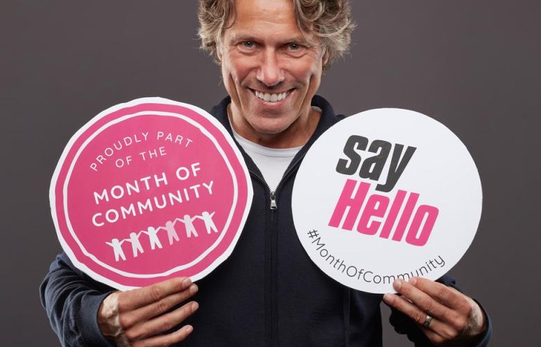 a man holds two signs that say "say hello"