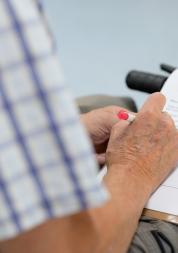 Man's hand completing a survey