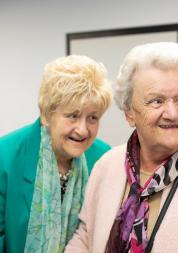 Two elderly women having a giggle together