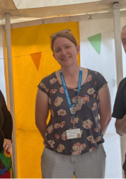 Three people stand in a tent and smile.